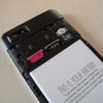 Telefon Fairphone cu capacul din spate demontat, cu bateria la vedere