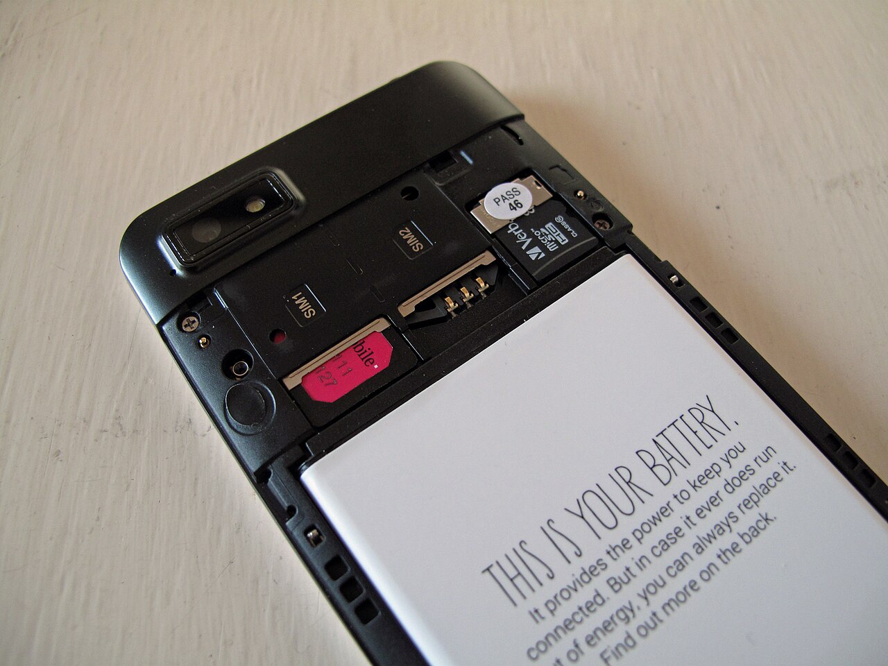 Telefon Fairphone cu capacul din spate demontat, cu bateria la vedere