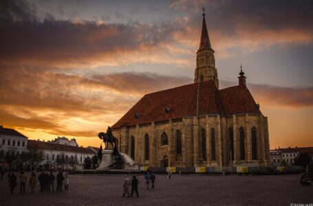 Biserica Sf. Mihail și Piața Unirii din Cluj-Napoca la apus, cu oameni în piață