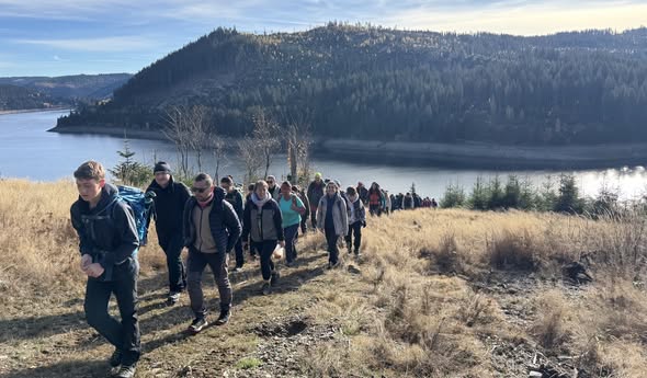 Drumeți pe traseul din zona Beliș, cu lacul în fundal